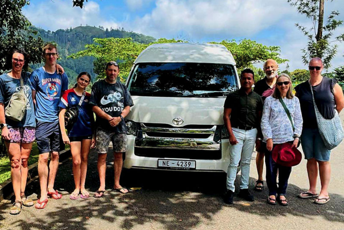 International travellers and their Sri Lankan driver beside a private charter van in the hill country